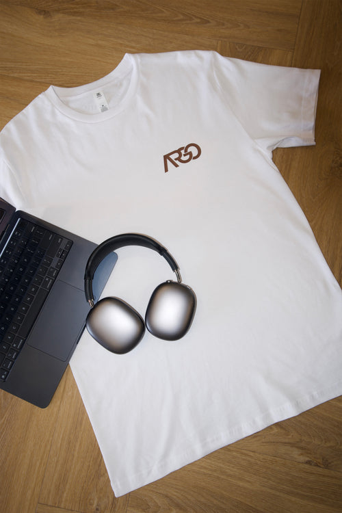 White Argo Co Working staple tee laid flat with laptop and headphones, Albion Brisbane coworking merch